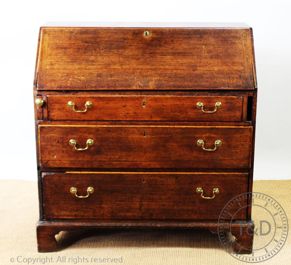 A George III provincial oak bureau, with fall over three long drawers, on bracket feet,