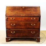 A George III provincial oak bureau, with fall over three long drawers, on bracket feet,