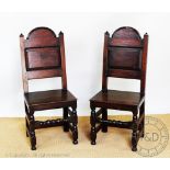 A pair of 17th century style dining chairs, with panelled backs and solid seats,