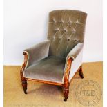 A William IV carved oak library chair, with button back upholstery and scroll end arms,