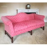 A George III style camel back sofa, with Peter Dudgeon red upholtery, on moulded mahogany legs,