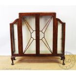A late Art Deco walnut display cabinet, with two doors, on claw and ball feet,