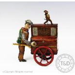 A vintage tin plate music box in the form of an organ grinder, his cart and a dancing monkey, 19.