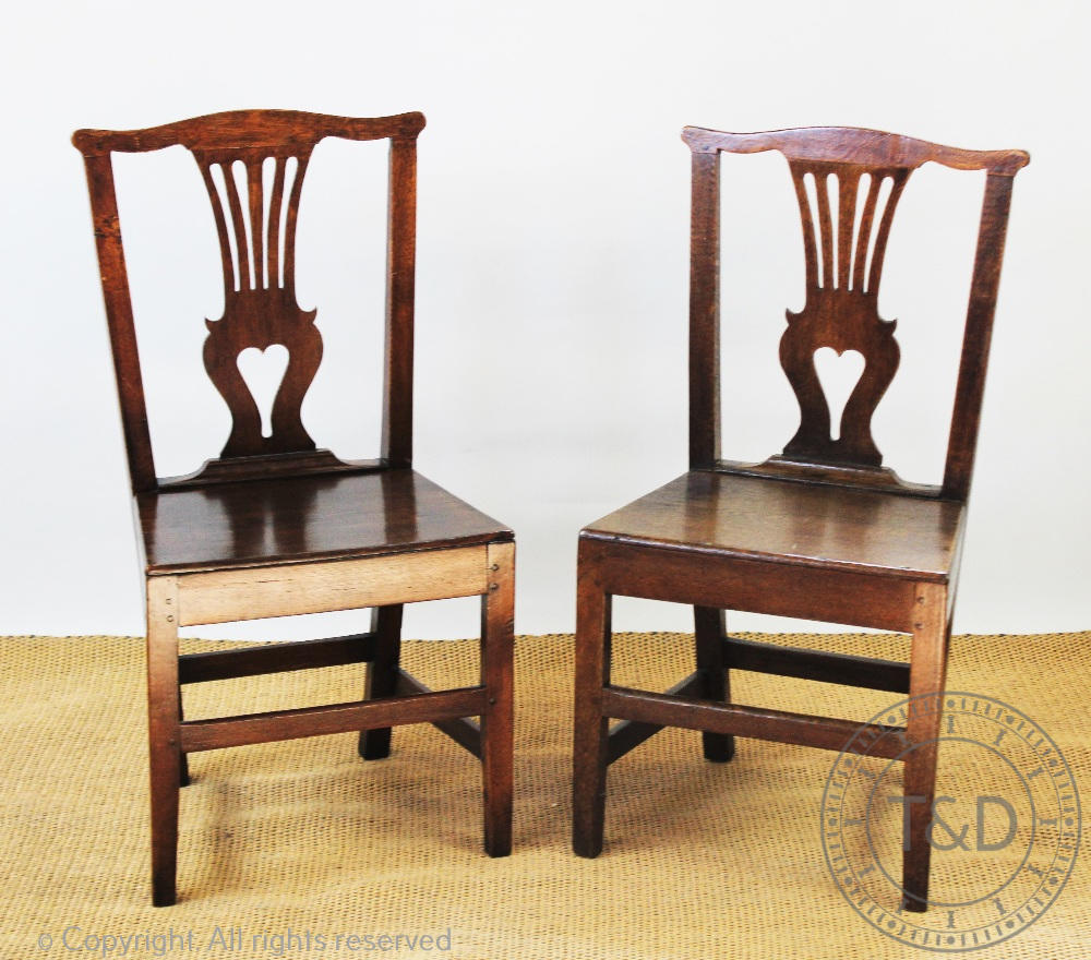 A set of six George III and later oak country kitchen chairs, with pierced splats and solid seats,