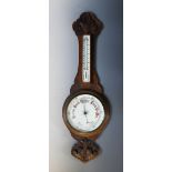 A Victorian carved oak aneroid wall barometer