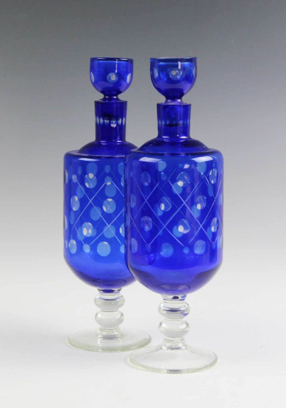 A near pair of Bohemian blue flashed glass decanters,