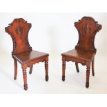 A pair of Victorian carved oak hall chairs,