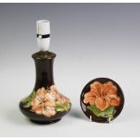 A Moorcroft table lamp in the Hibiscus pattern on a brown ground,