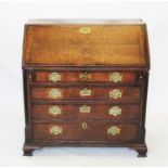 A George III oak and mahogany crossbanded bureau,