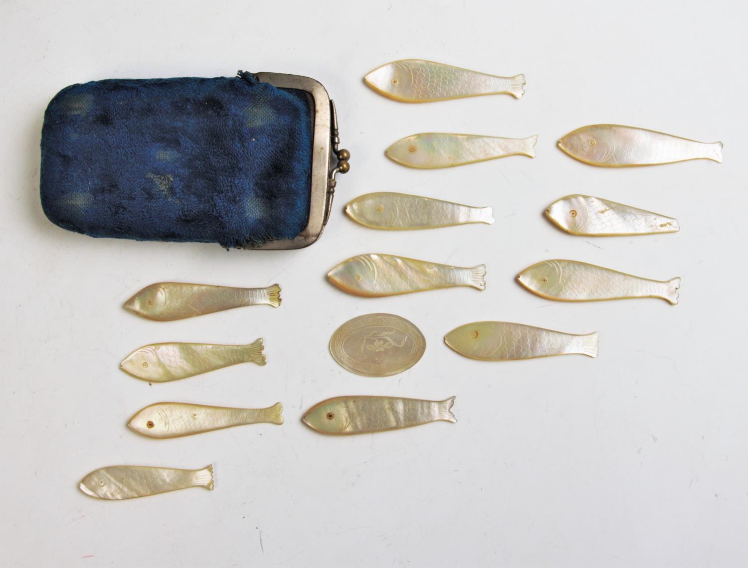 An assorted collection of mother of pearl carved counters in the form of fish