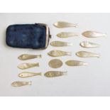 An assorted collection of mother of pearl carved counters in the form of fish