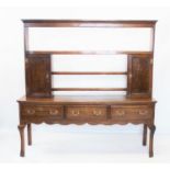 An 18th century oak high back Welsh dresser, the open rail back flanked by two spice cupboards