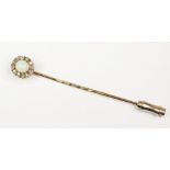 An opal and diamond set stick pin, designed as a central oval opal,