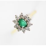 An emerald and diamond oval cluster ring,