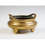 A Chinese polished bronze tripod censer,