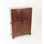 A 19th century oak cabinet, the two panelled doors enclosing five shelves on bun feet,