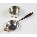 A silver tea strainer and stand,