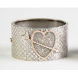 A Victorian sentimental bangle, the half hinged bangle designed as a gilt relief heart design