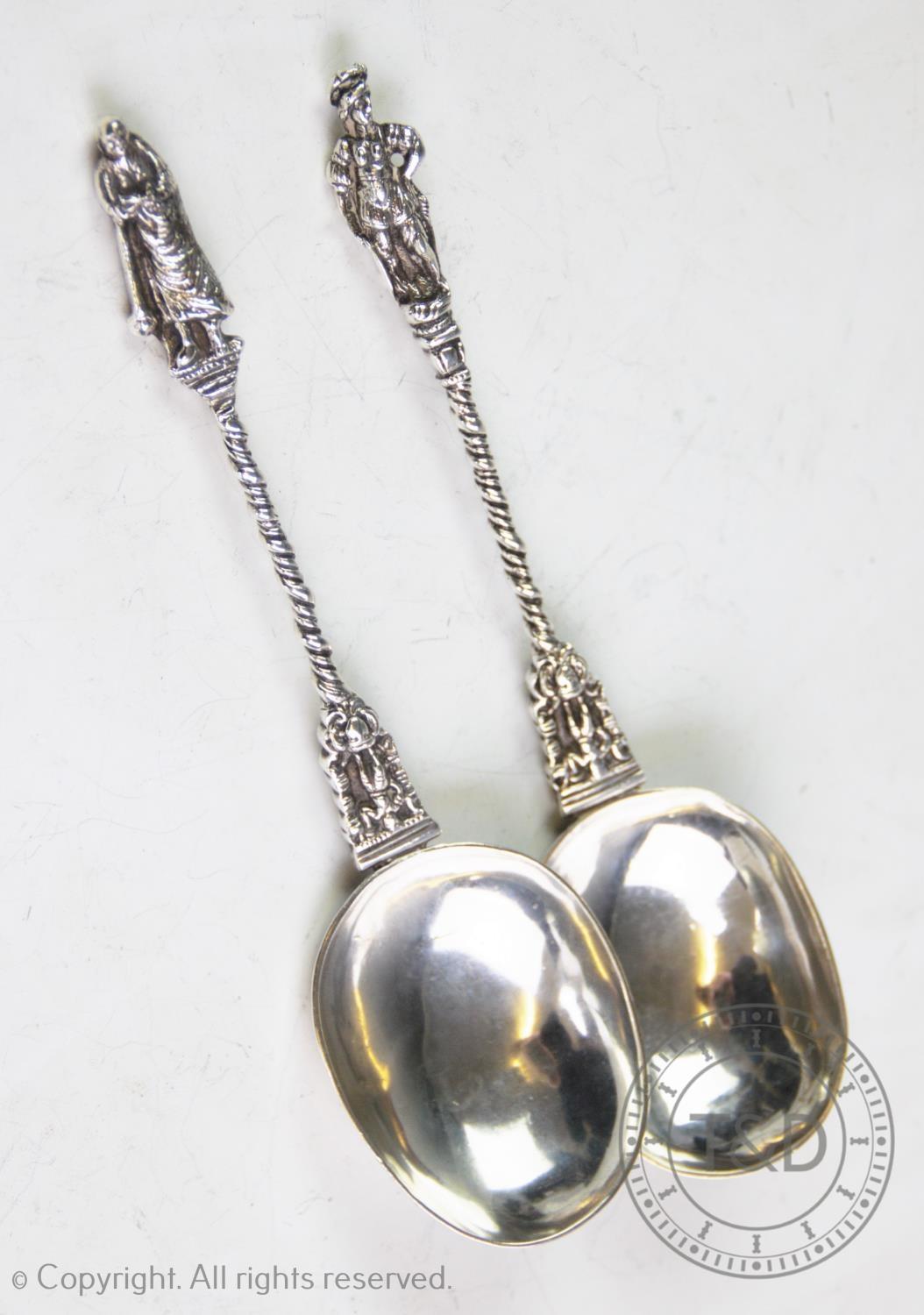 A pair of continental white metal apostle spoons, with oval bowls, chased and rope-twist stems and