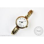 A lady's wristwatch, the circular case enclosing a white enamel dial with black numerals and