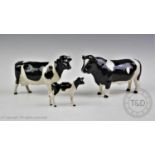 A Beswick Friesian cattle family, comprising a bull, a cow and a calf, each with maker's mark to