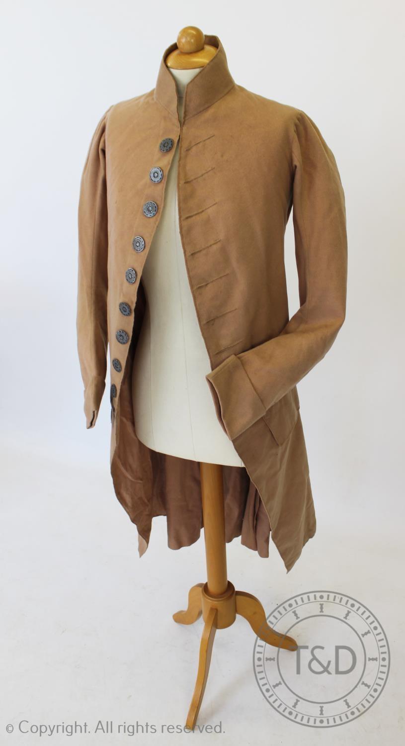 A blush wool frock coat, circa 1790, with pierced silvered metal buttons to front and back (at