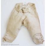 A pair of ivory silk breeches, circa 1780, decorated with a stripe with red and green flecks
