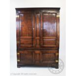 An 18th Century oak housekeepers cupboard, with a moulded cornice above two panelled cupboard