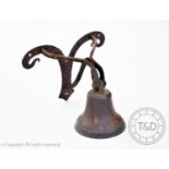 A 19th century wall mounted bronze bell, with an iron work wall bracket, bell 21cm high, bracket