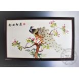 A Chinese silk embroidery depicting a peacock perched in a tree, 62cm x 106.5cm, framed and