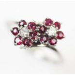A ruby and white sapphire floral cluster ring, comprising two brilliant cut white sapphires, each