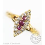 An Edwardian ruby and diamond ring, the marquise shaped ring set with three central graduated rubies