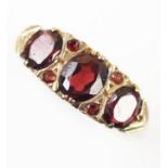 A three stone garnet set 9ct gold dress ring, set with three mixed cut oval garnets, claw set to