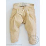 A pair of beige fine linen breeches, circa 1790, with fall front and brass buttons, with a pair of
