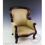 A Victorian mahogany childs armchair, the arched back with a leaf and flower head carved crest above