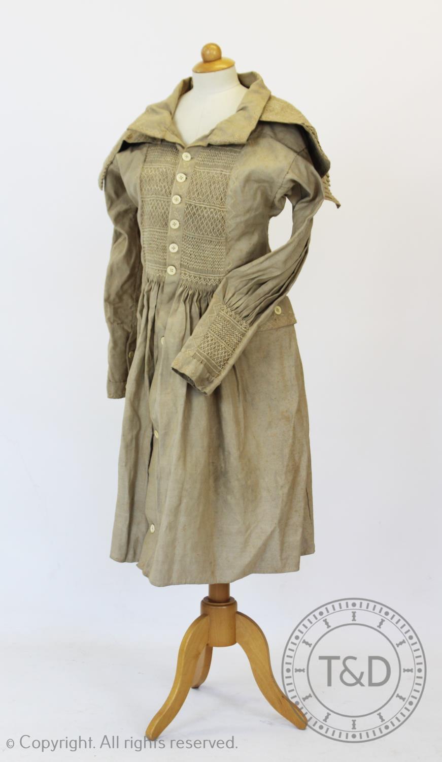 An early 19th century natural heavy twill cotton smock, with smocked detail to the front, back and