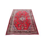 A Persian Saruq carpet, decorated with a floral design against a red ground, 210cm x 303cm