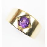 An amethyst set ring, the central round mixed cut amethyst claw set to plain polished yellow metal