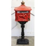 A Victorian style cast iron letter box, of pagoda form with a gilt crown finial above a hinged