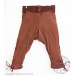 A rare pair of men?s breeches, circa 1820, in brown, with striped woollen waistband, and silk