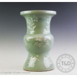 A large Chinese porcelain celadon glazed vase, of archaic gu form, decorated with sprigs of