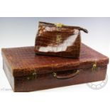 An early 20th century crocodile skin travel case, with a satin lined interior, loop handle and