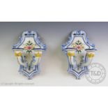 A pair of Portuguese faience wall sconces, each hand painted with floral and foliate decoration,