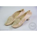 A pair of late 19th century wedding shoes, the ivory silk shoes with beaded heart and pleated