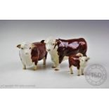 A Beswick Red Hereford cattle family, comprising a bull, a cow and a calf, the bull with maker's