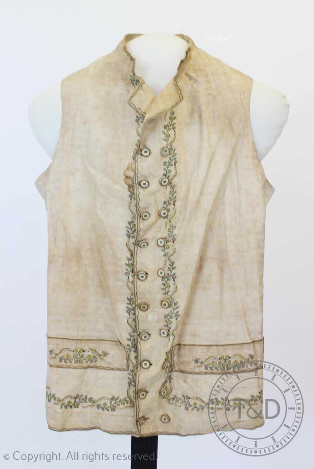 An ivory striped woven cotton waistcoat, circa 1800, the edges decorated with foliate sprays and