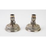 A pair of Victorian silver candlesticks, Carrington & Co, London 1890, upon domed bases, repousse
