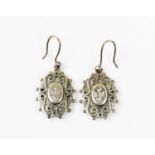 A pair of Victorian drop earrings, the white metal oval shaped panels with engraved and applied