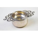 A George V silver tea strainer, Marson & Jones, Birmingham 1932, with pierced patterned handles,