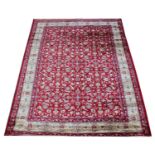A red ground Kashmir rug with an all-over floral design and gold border, 230cm x 160cm